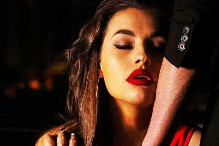 Foto do rosto de uma mulher de olhos fechados, com cara de desejo enquanto se pode ver o braço de um homem encostando em seu rosto. A foto ilustra o artigo 10 Melhores Maneiras como a Psicanálise Impulsiona a Autoidentidade escrito pelo psicanalista Homero Mônaco para o site Online Psicanalista.