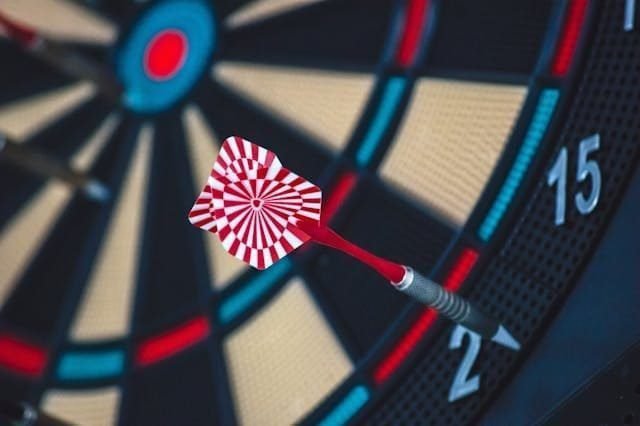 Foto de um alvo com um dardo atingindo a meta. A foto ilustra o artigo 10 Estratégias para Transformar os seus Padrões de Comportamento escrito pelo psicanalista Homero Mônaco para o site Online Psicanalista.