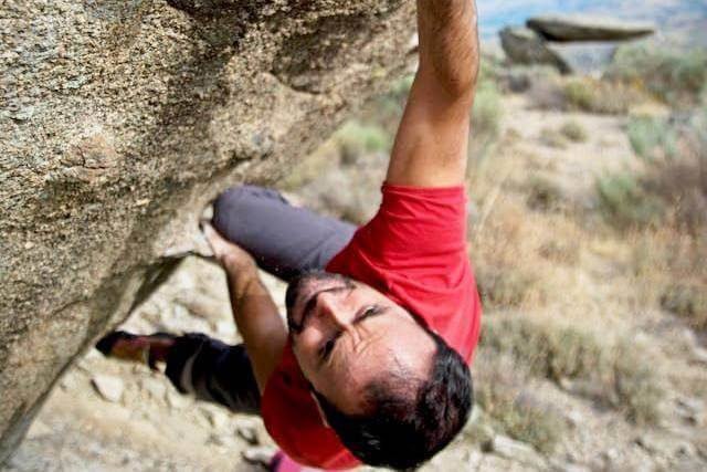 Foto de um homem escalando uma pedra apenas coma força das mãos. A foto ilustra o artigo 10 Maneiras de Alcançar o Empoderamento Pessoal Com a Psicanálise escrito pelo psicanalista Homero Mônaco para o site Online Psicanalista.