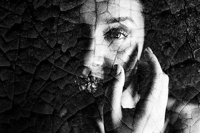 Foto do rosto de uma mulher de frente. O rosto da mulher parece craquelado e desconfigurado. A foto ilustra o artigo O que são Transtornos de Personalidade? Quais são os tipos? Quais são os sintomas? Como tratá-los? escrito pelo psicanalista Homero Mônaco para o site Online Psicanalista.
