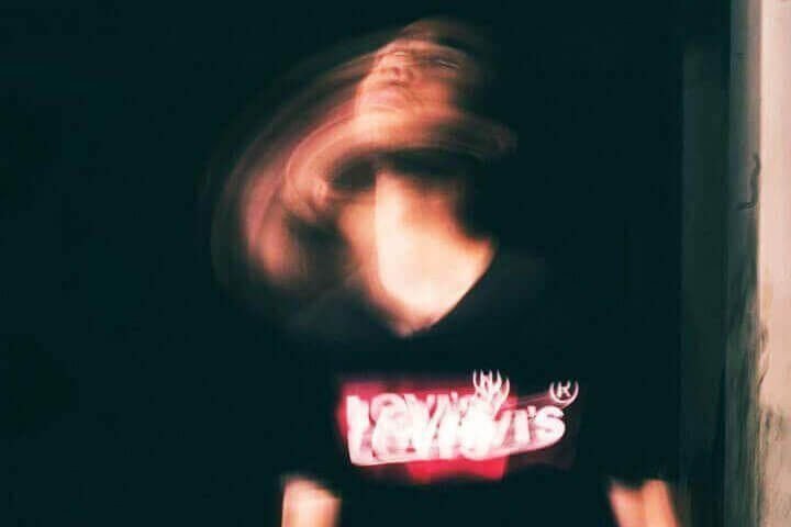 Foto de um jovem sentado no chão, onde a foto mostra movimento e um efeito de sombra de movimento da sua imagem como se tivesse sofrendo uma alucinação. A foto ilustra o artigo O que são transtornos psicológicos? Quais são eles? Como tratá-los? escrito no blog do psicanalista Homero Mônaco para ao site Online Psicanalista.