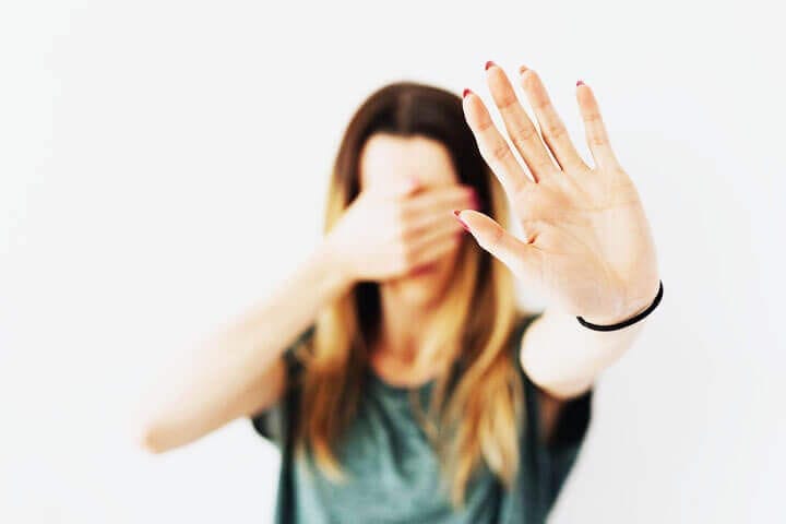 Foto de uma mulher tampando os olhos e com o braço esquerdo esticado para frente como um sinal de que quer afastar algo que não quer ver e lhe dá medo. A foto ilustra o artigo O tratamento psicanalítico pode apagar completamente as cicatrizes emocionais? escrito pelo psicanalista Homero Mônaco para o site Online Psicanalista. Foto de uma menina com perna levantada como se fosse pisar na lente da câmera que a fotografa. A foto ilustra o artigo Por que a psicanálise oferece ajuda genuína para fobias? escrito pelo psicanalista Homero Mônaco para o site Online Psicanalista.