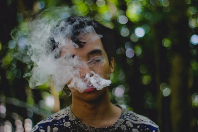 Foto de um homem soltando fumaça pela boca. A fumaça cobre a sua cara. A foto ilustra o artigo Revelando as Forças Ocultas na Recuperação da Dependência escrito pelo psicanalista Homero Mônaco para o site Online Psicanalista.