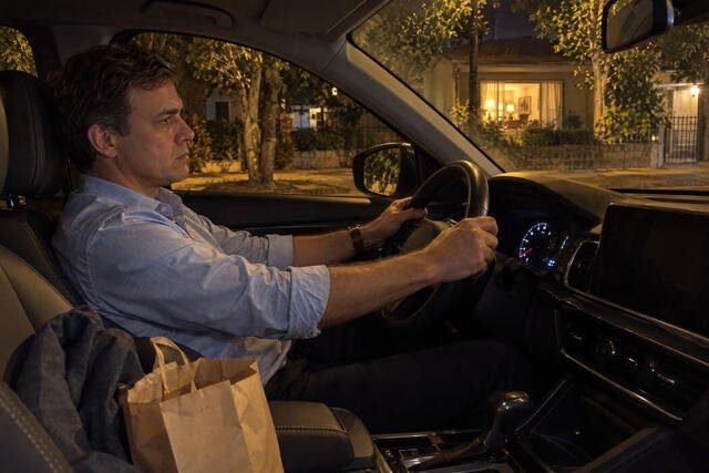 Homem sentado dentro do carro, estacionado em frente à casa dos pais, com expressão de irritação e desconforto depois de uma visita familiar. A cena representa a frustração de perceber que voltou a reagir de uma maneira que gostaria de ter superado. Imagem utilizada para ilustrar o artigo “Diante de quem te viu crescer, mudar fica mais difícil, você já notou isso?” escrito por Homero Mônaco Psicanalista especializado em neurociências e comportamento.